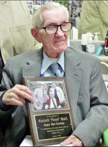 A PLAQUE FOR AMERICA'S BARBER--Russell Hiatt of Floyd's City Barber Shop poses with a plaque of appreciation presented to him by Downtown Mount Airy, Inc., on January 28, his 92nd birthday. (Oh, and Goober reminds us...there was a cake, too!)