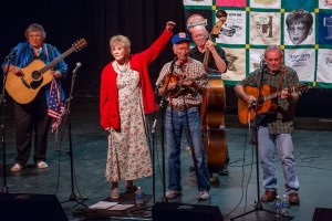 DARLING PERSONS--Maggie Peterson gives Dean Webb a hand as longtime Doug Dillard Band members Ginger Boatwright and Roger Rasnake play guitar and Buddy Griffin plays bass during the Doug Dillard Memorial Concert at the 2012 Mayberry Days. Photo by Hobart Jones.