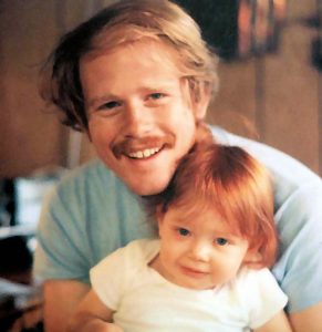 1983 Ron holds an almost 2-year-old Bryce in his arms as she rests on his lap.